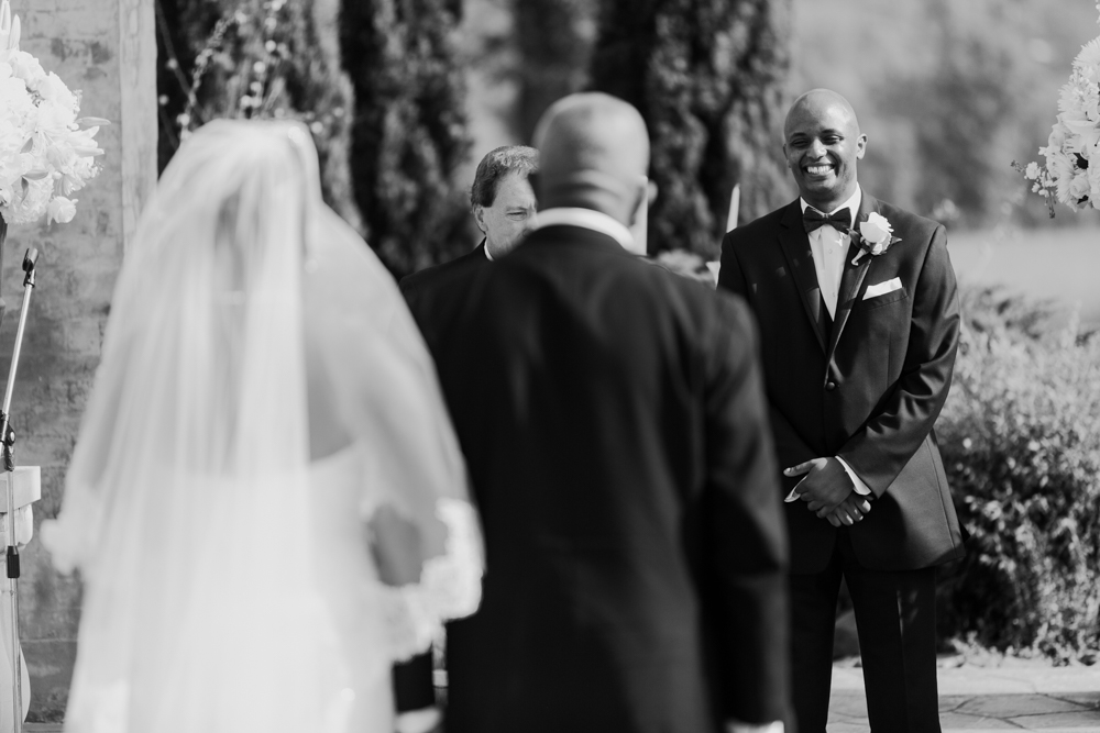 Groom is seen smiling at the bride who is walking down the aisle toward him arm in arm with her father.

Luxury Texas Wedding Photographer. Timeless Wedding Photography. Wedding in Texas. Destination Wedding Photographer.