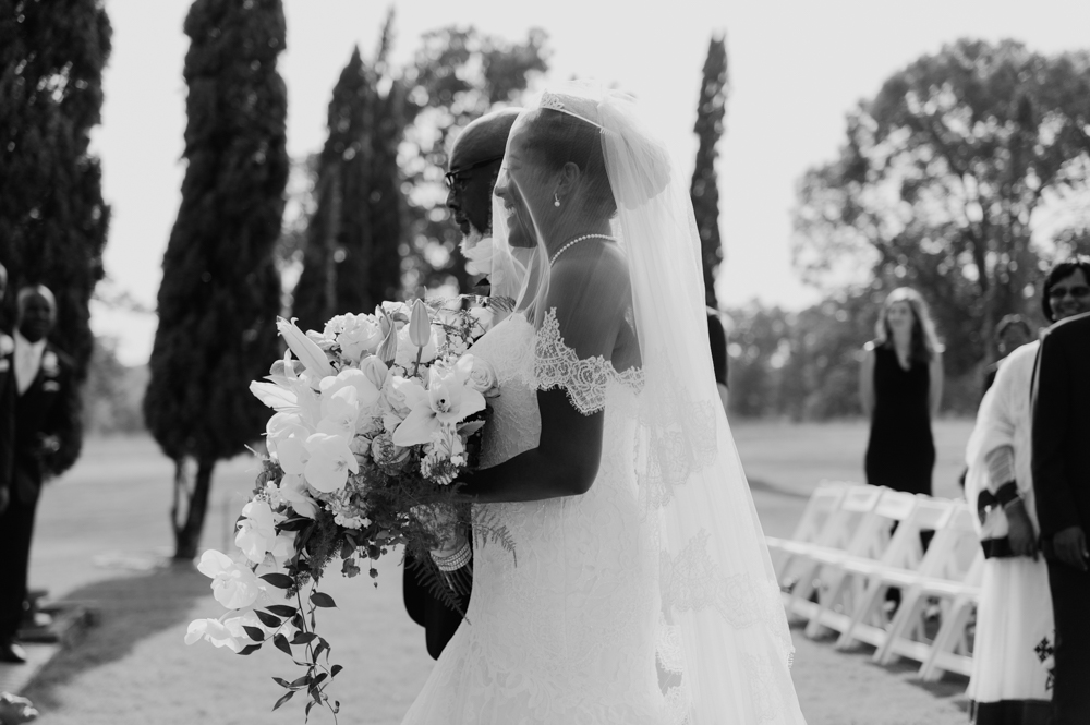 Sde profile view of the bride walking down the aisle with her father. She is holding a large bouquet and a veil covers her face.

Luxury Texas Wedding Photographer. Timeless Wedding Photography. Wedding in Texas. Destination Wedding Photographer.