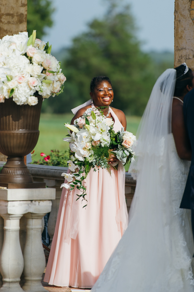 Bridesmaid holds the bride's bouquet and smiles at the camera.

Luxury Texas Wedding Photographer. Timeless Wedding Photography. Wedding in Texas. Destination Wedding Photographer.