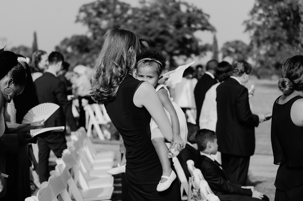 An infant is held in a wedding guest's arms at the wedding ceremony.

Luxury Texas Wedding Photographer. Timeless Wedding Photography. Wedding in Texas. Destination Wedding Photographer.