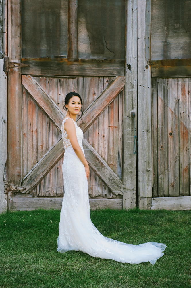 Bride stands on the grass outside a barn door and looks at the camera with a soft smile.

Highlands Country Club Wedding. Upstate NY Wedding Photographer. Luxury Wedding Photographer. Upstate New York Wedding Photography.