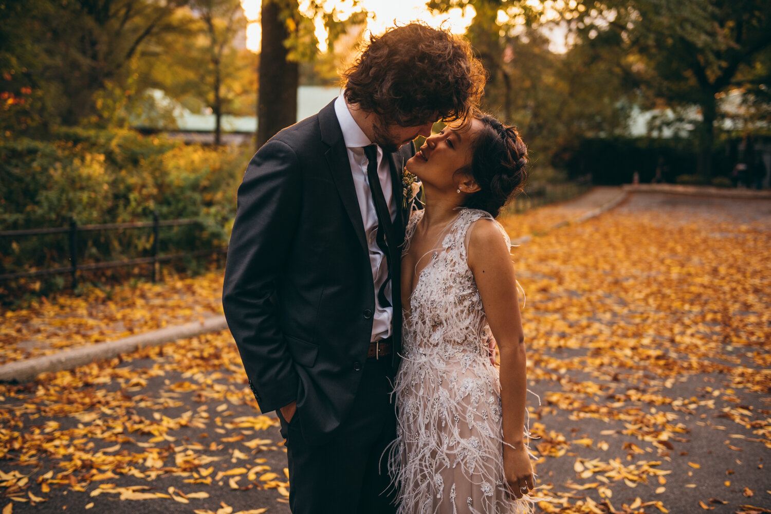 Bride and groom stand facing each other and are an inch away from a kiss. Fall foliage covers the ground behind them in Central Park.

Central Park Wedding Photography. Williamsburg Bridge Bridal Portraits. Luxury NYC Wedding Photographer. Manhattan Micro Wedding.