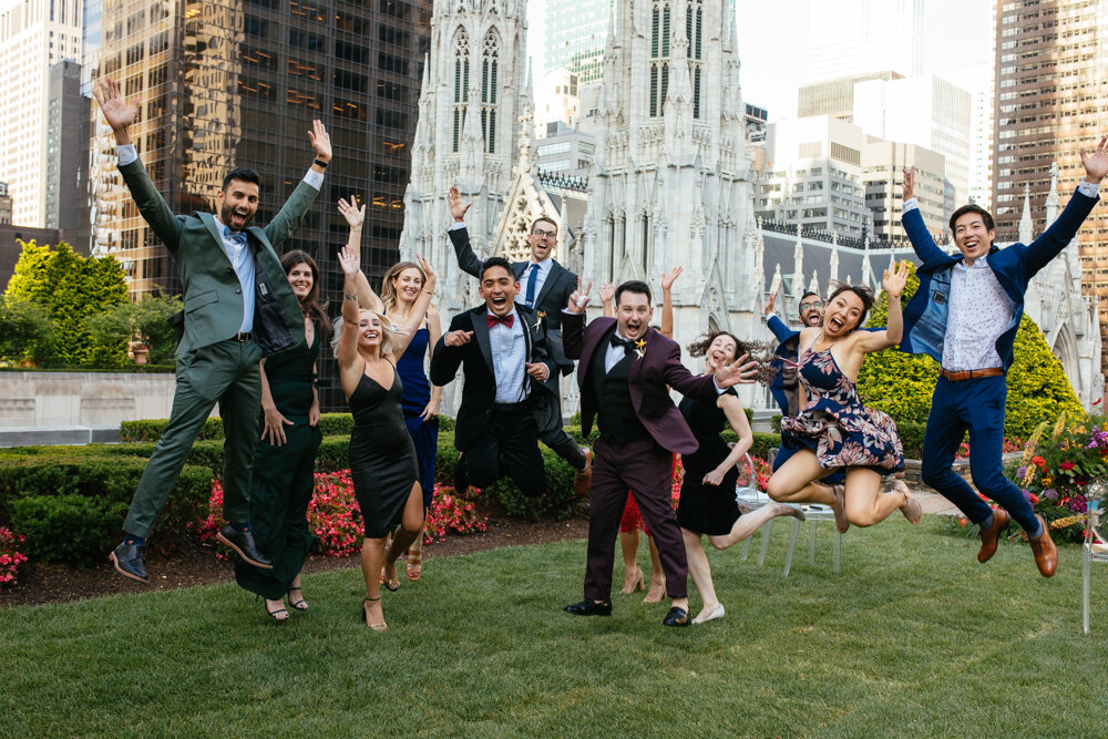 Grooms and wedding guests all jump up with their hands in the air smilign at the camera.

Luxury NYC Wedding Photography. Queer Wedding Photography. Inclusive Wedding Photographer. LGBTQ+ Manhattan Wedding.