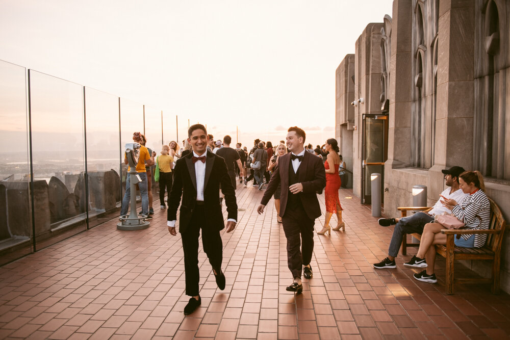 Two grooms walk along the Top of the Rock smiling as Top of the Rock guests wander in the background.

Luxury NYC Wedding Photography. Queer Wedding Photography. Inclusive Wedding Photographer. LGBTQ+ Manhattan Wedding.