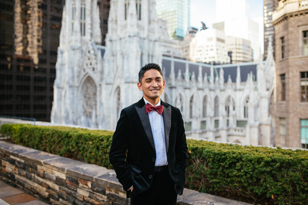 A groom stands in a black velvet tuxedo at the Top of the Rock. St. Patrick's Cathedral is visible behind him.

Luxury NYC Wedding Photography. Queer Wedding Photography. Inclusive Wedding Photographer. LGBTQ+ Manhattan Wedding.