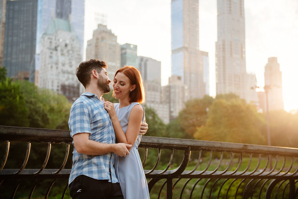 Man and woman stands with their arms around each other and looking into each other's eyes with Central Park and the Manhattan skyline behind them.

Central Park Engagement Portraits. Manhattan Engagement Photography. NYC Engagement Photographer.
