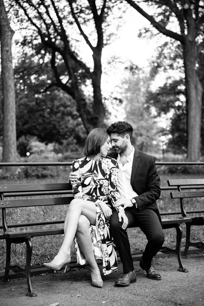 Man and woman sit on a bench in Central Park and touch foreheads. Her hand is on his leg and his arm is around her.

Central Park Engagement Portraits. Manhattan Engagement Photography. NYC Engagement Photographer.