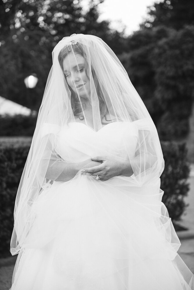 Bride stands outside in the garden with her veil over her face. She is looking down to the side with a smile on her face and her hands are held in front of her outside the veil.

Luxury Local Wedding NYC. Wedding in Manhattan. New York City Wedding Photographer. Manhattan Luxury Wedding Photography. Museum of the City of New York Weddings.