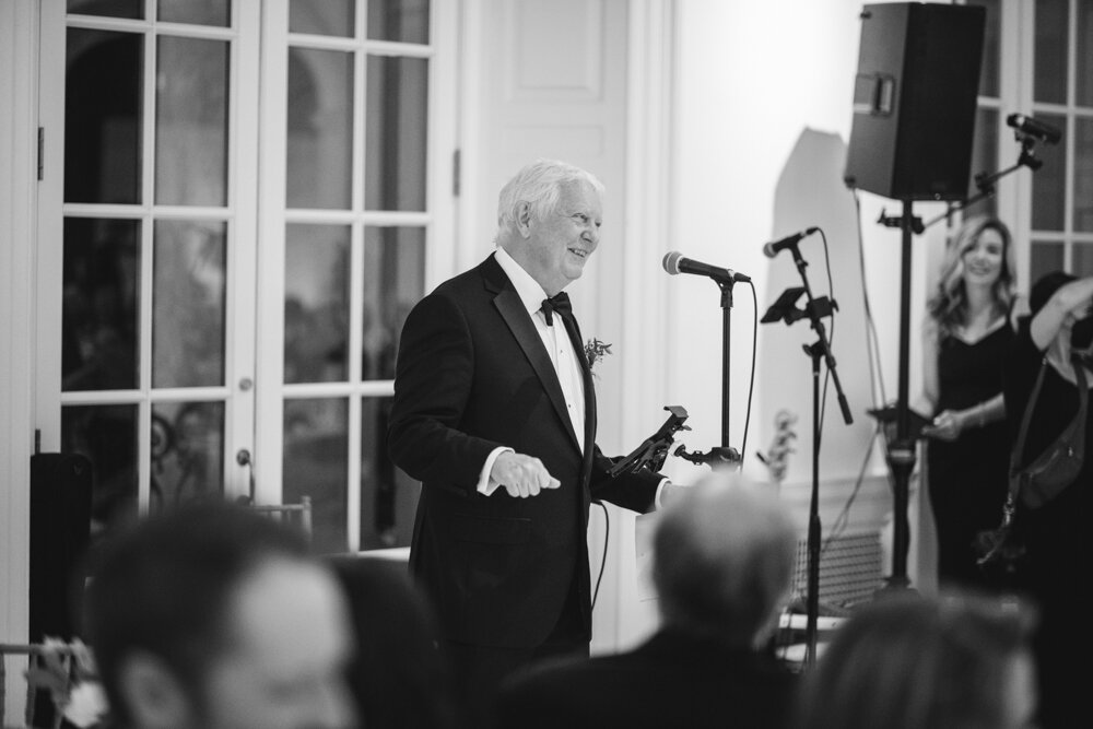 The father of the bride delivers a speech at a microphone.

Luxury Local Wedding NYC. Wedding in Manhattan. New York City Wedding Photographer. Manhattan Luxury Wedding Photography. Museum of the City of New York Weddings.