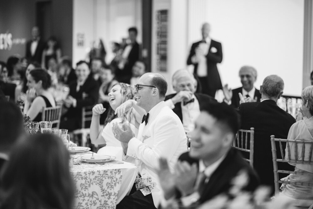 The bride and groom are seated among their wedding guests and laugh.

Luxury Local Wedding NYC. Wedding in Manhattan. New York City Wedding Photographer. Manhattan Luxury Wedding Photography. Museum of the City of New York Weddings.