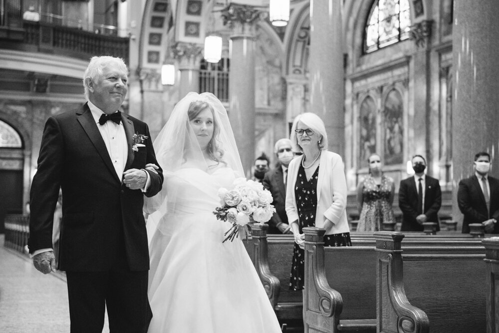 Bride and her father walk down the aisle arm in arm as standing wedding guests look on with smiles.

Luxury Local Wedding NYC. Wedding in Manhattan. New York City Wedding Photographer. Manhattan Luxury Wedding Photography. Museum of the City of New York Weddings.