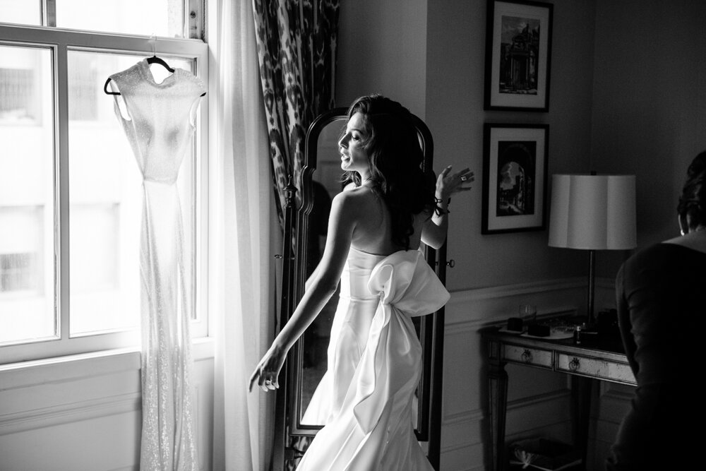 Bride stands in front of a mirror with her wedding dress on. She has her arms out and her head is turned to the side.

University Club Wedding Photographer. Manhattan Luxury Wedding Photographer. Manhattan Bridal Portraits. Luxury Local Wedding NYC. 