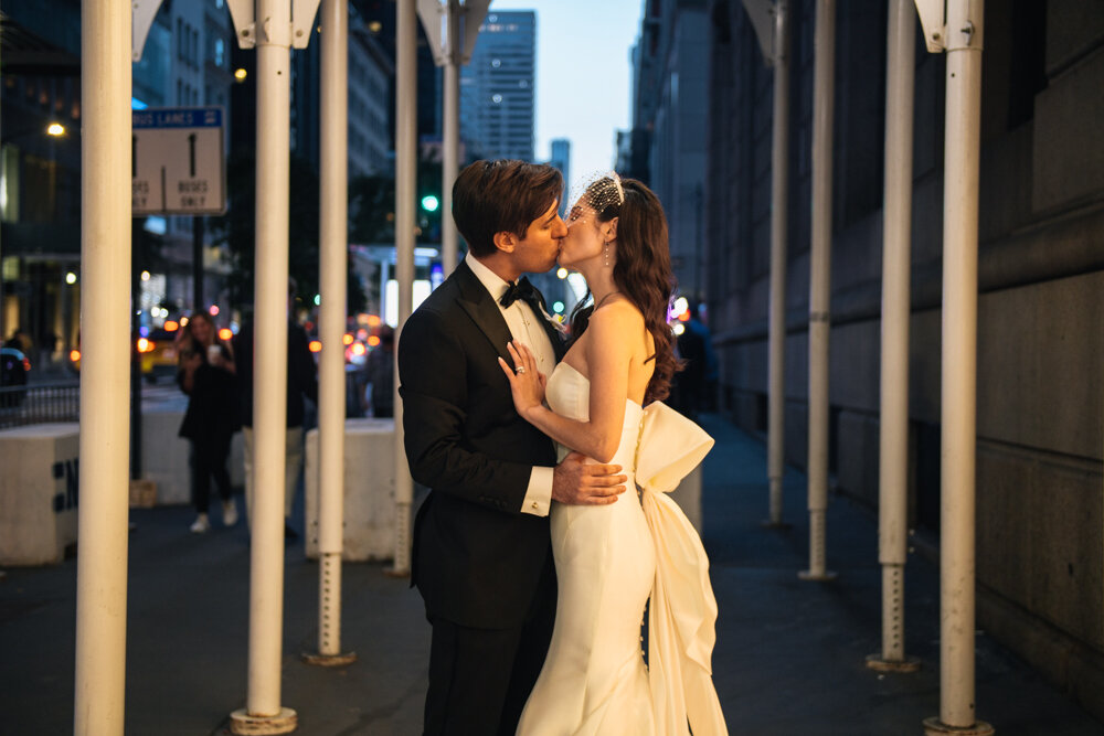 Bride and groom kiss each other on a New York City sidewalk under scaffolding.

University Club Wedding Photographer. Manhattan Luxury Wedding Photographer. Manhattan Bridal Portraits. Luxury Local Wedding NYC. 