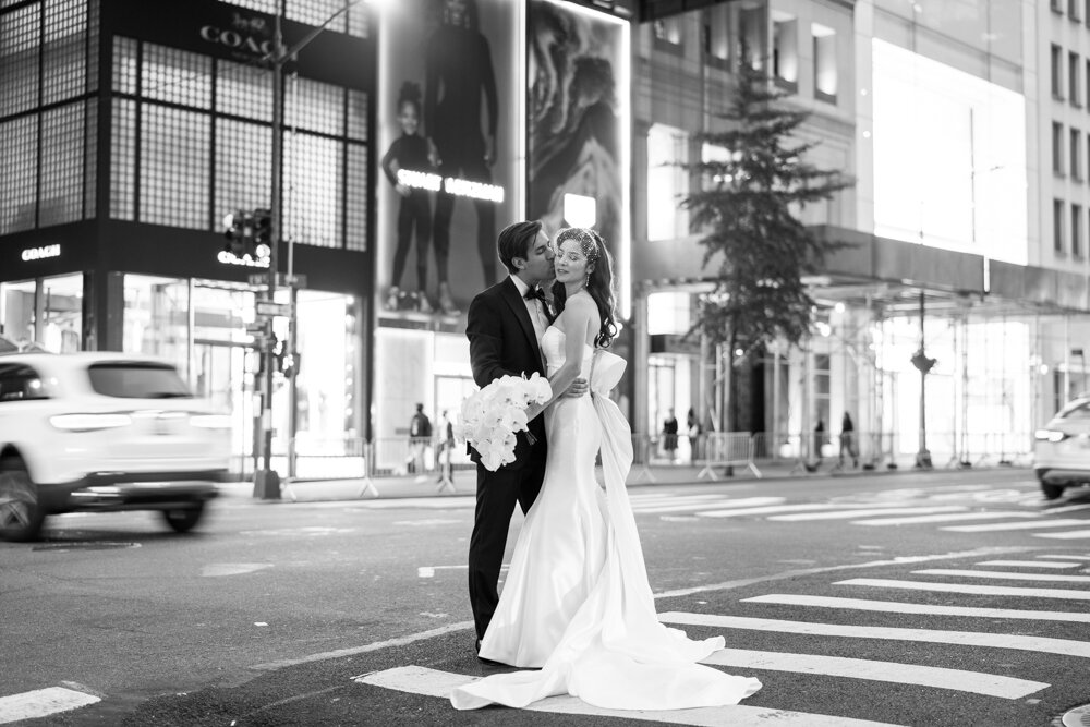 Bride and groom stand in a crosswalk in Manhattan and groom kisses bride on cheek.

University Club Wedding Photographer. Manhattan Luxury Wedding Photographer. Manhattan Bride and Groom Portraits. Luxury Local Wedding NYC. 