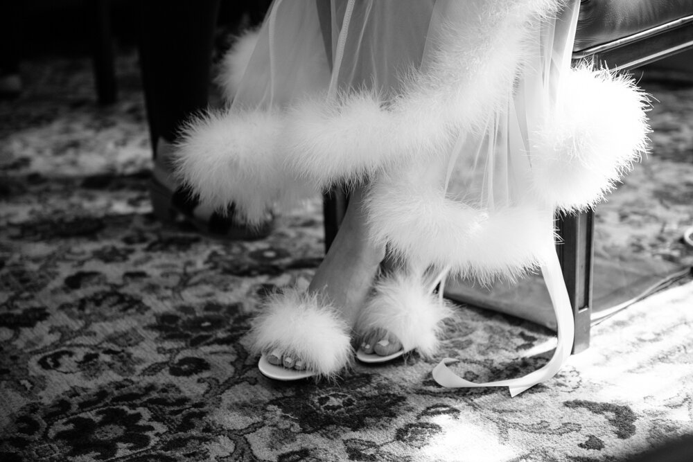 Close-up of bride's heels and the bottom of her dress, both ith white feather details.

University Club Wedding Photographer. Manhattan Luxury Wedding Photographer. Manhattan Bridal Portraits. Luxury Local Wedding NYC. 