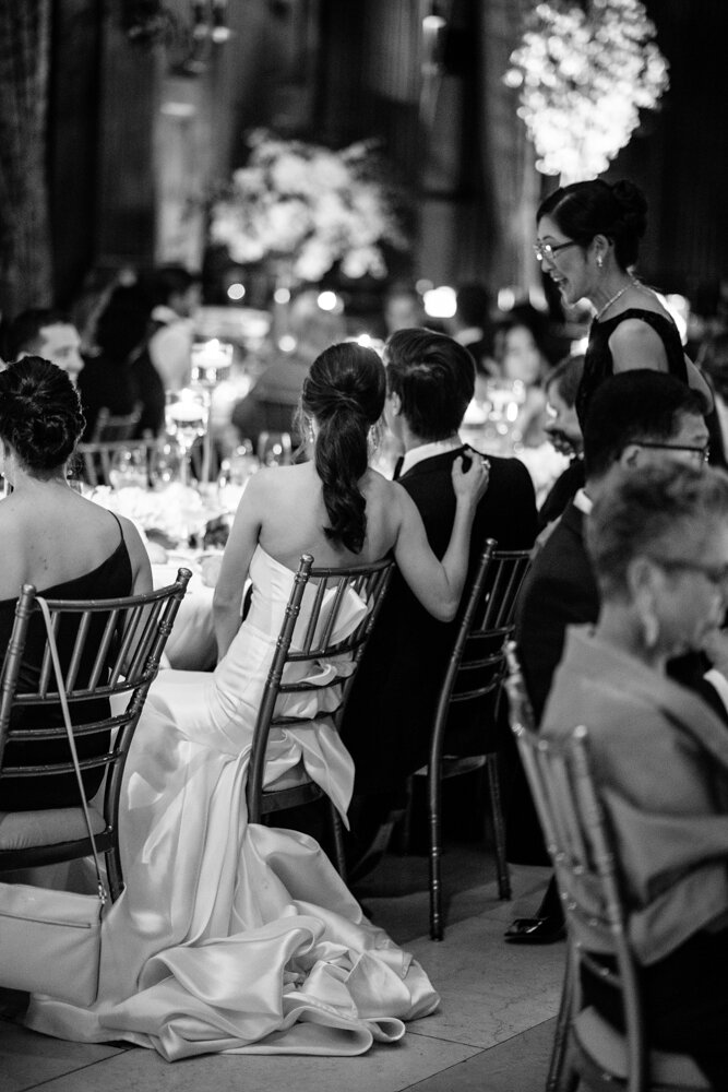 Bride and groom photographed from behind as they are seated at their table. Her arms is on his back.

University Club Wedding Photographer. Manhattan Luxury Wedding Photographer. Manhattan Bridal Portraits. Luxury Local Wedding NYC. 