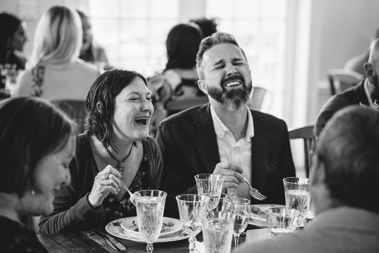 Wedding guests laugh as they eat their food at the wedding reception.

Upstate New York Wedding Photography. Cold Spring NY Wedding Photography. Luxury Local Wedding Photographer. Destination Wedding Photographer.