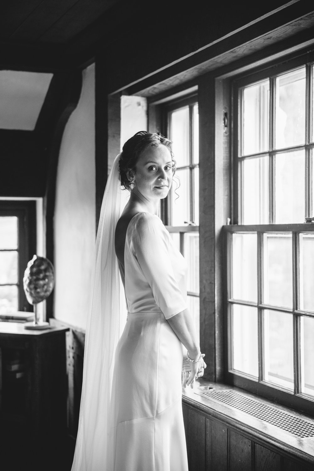 Bride stands facing a window and looks to the side and smiles at the camera.

Upstate New York Wedding Photography. Cold Spring NY Wedding Photography. Luxury Local Wedding Photographer. Destination Wedding Photographer.