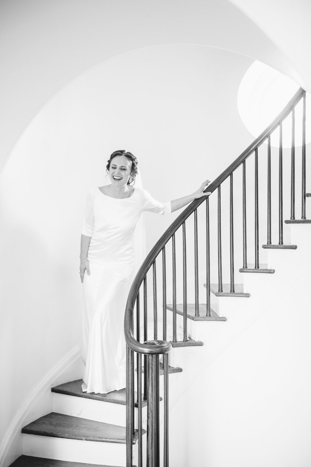 Bride smiles as she walks down a spiral staircase in her wedding dress.

Upstate New York Wedding Photography. Cold Spring NY Wedding Photography. Luxury Local Wedding Photographer. Destination Wedding Photographer.