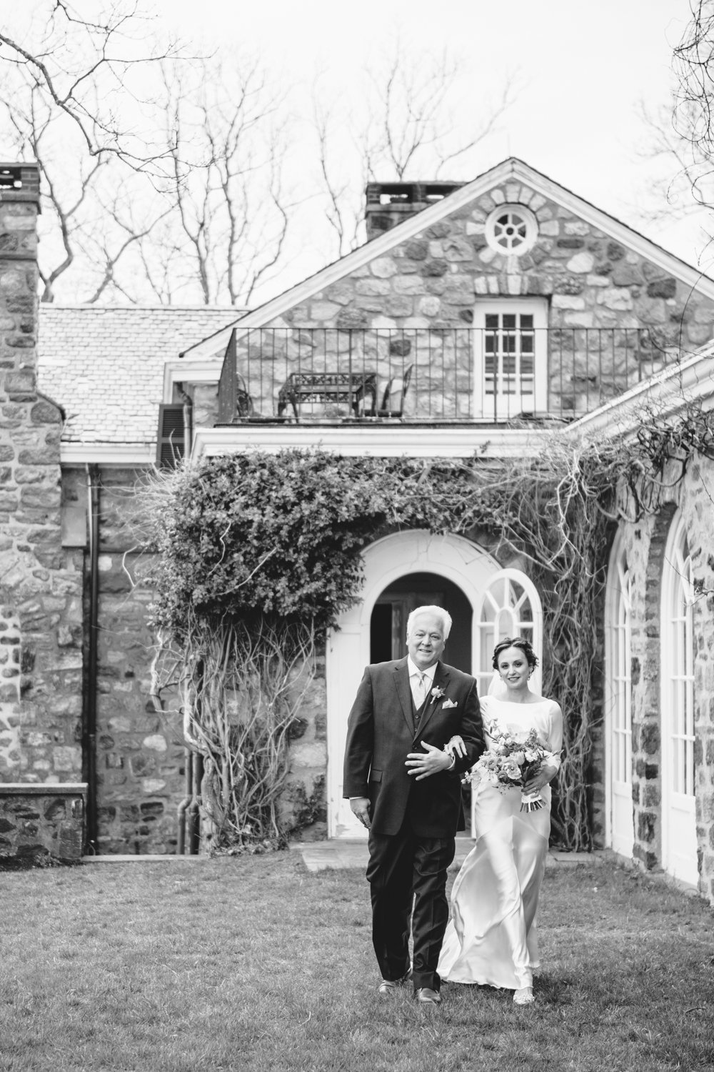 Bride and her father walk arm in arm away from a stone cottage.

Upstate New York Wedding Photography. Cold Spring NY Wedding Photography. Luxury Local Wedding Photographer. Destination Wedding Photographer.