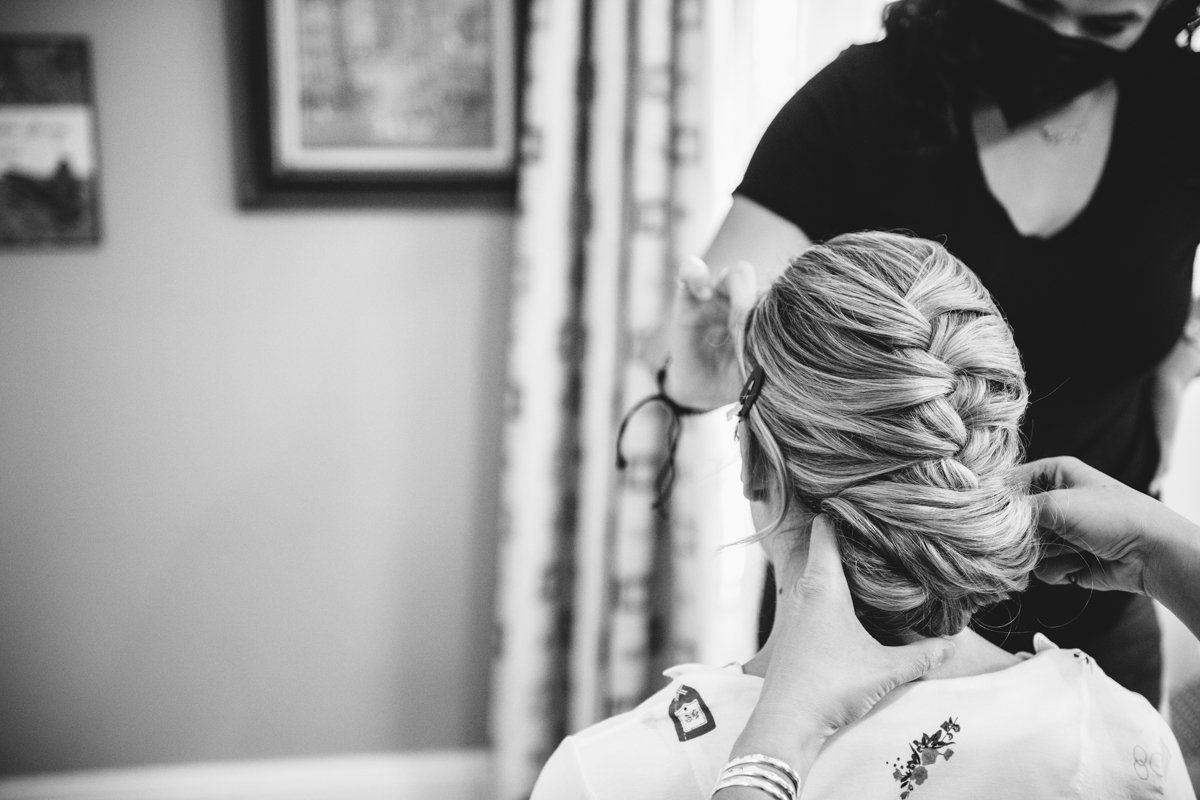 Bride is seated facing away from the camera with two sets of hands reaching into frame working on her braided bun hairstyle and her makeup.

New York Wedding Photography. Long Island Wedding Photography. Luxury Local Wedding Photographer. Destination Wedding Photographer.