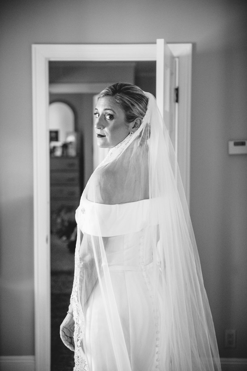 Bride stands in front of a doorway with her wedding dress and veil on and looks over her shoulder at the camera.

New York Wedding Photography. Long Island Wedding Photography. Luxury Local Wedding Photographer. Destination Wedding Photographer.