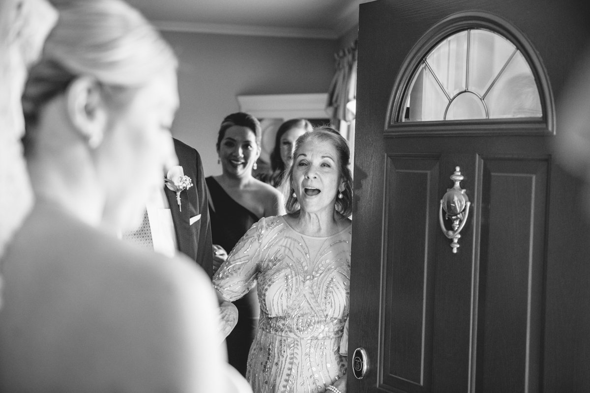 Bride is out of focus in the foreground as her family is in focus through a doorway smiling at her.

New York Wedding Photography. Long Island Wedding Photography. Luxury Local Wedding Photographer. Destination Wedding Photographer.