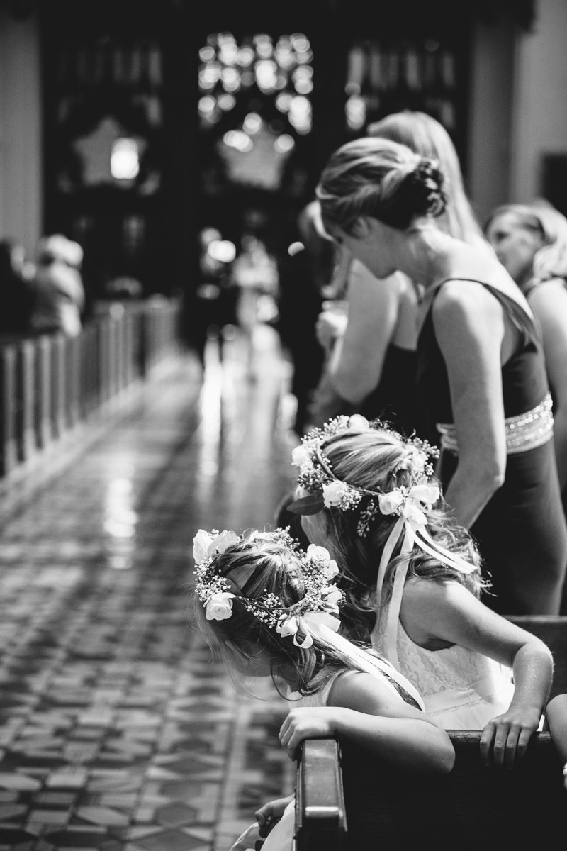 Flower girls with flower crowns on their heads lean over the church pews to see the bride walking down the aisle.

New York Wedding Photography. Long Island Wedding Photography. Luxury Local Wedding Photographer. Destination Wedding Photographer.