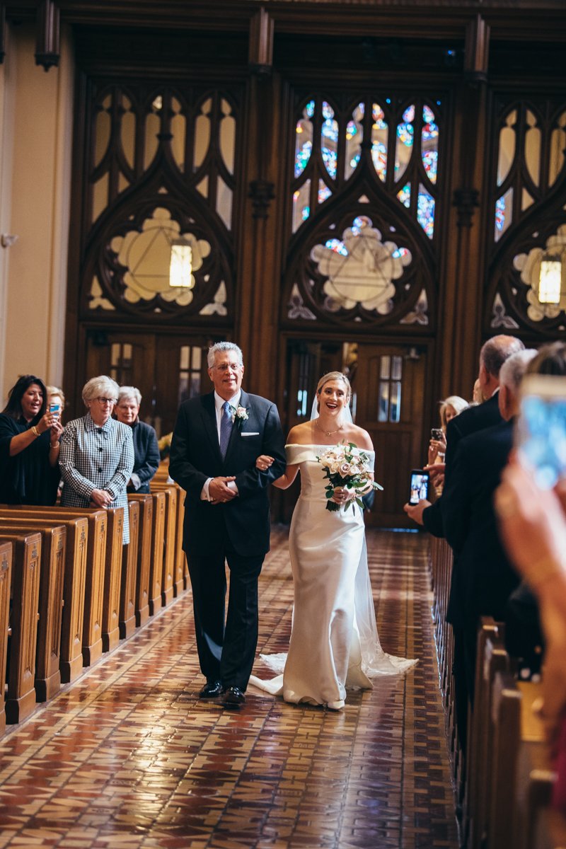 Bride is walked down the aisle by her father with a smile on her face.

New York Wedding Photography. Long Island Wedding Photography. Luxury Local Wedding Photographer. Destination Wedding Photographer.