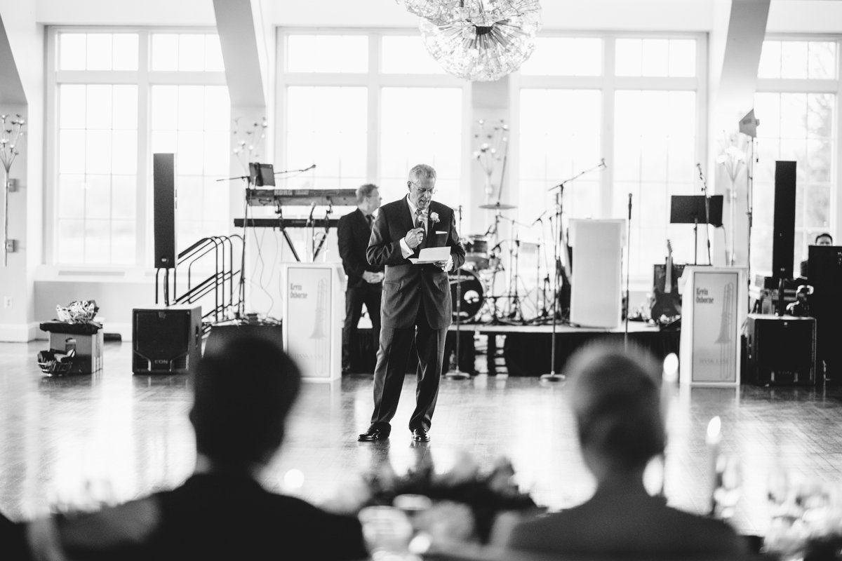 Man stands on the dance floor at the reception with a microphone in his hand as he reads from a paper in his other hand.

New York Wedding Photography. Long Island Wedding Photography. Luxury Local Wedding Photographer. Destination Wedding Photographer.