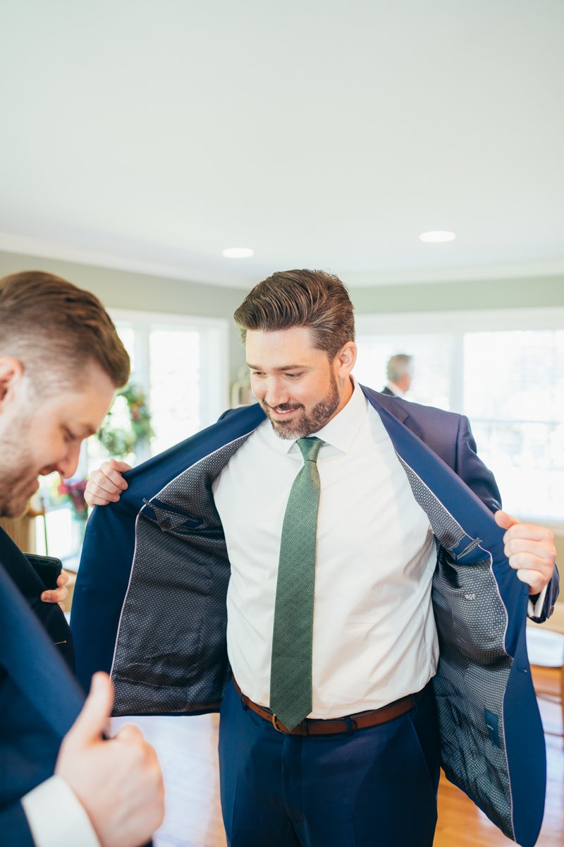Groom lifts open his suit jacket as he smiles at his groomsman.

New York Wedding Photography. Long Island Wedding Photography. Luxury Local Wedding Photographer. Destination Wedding Photographer.