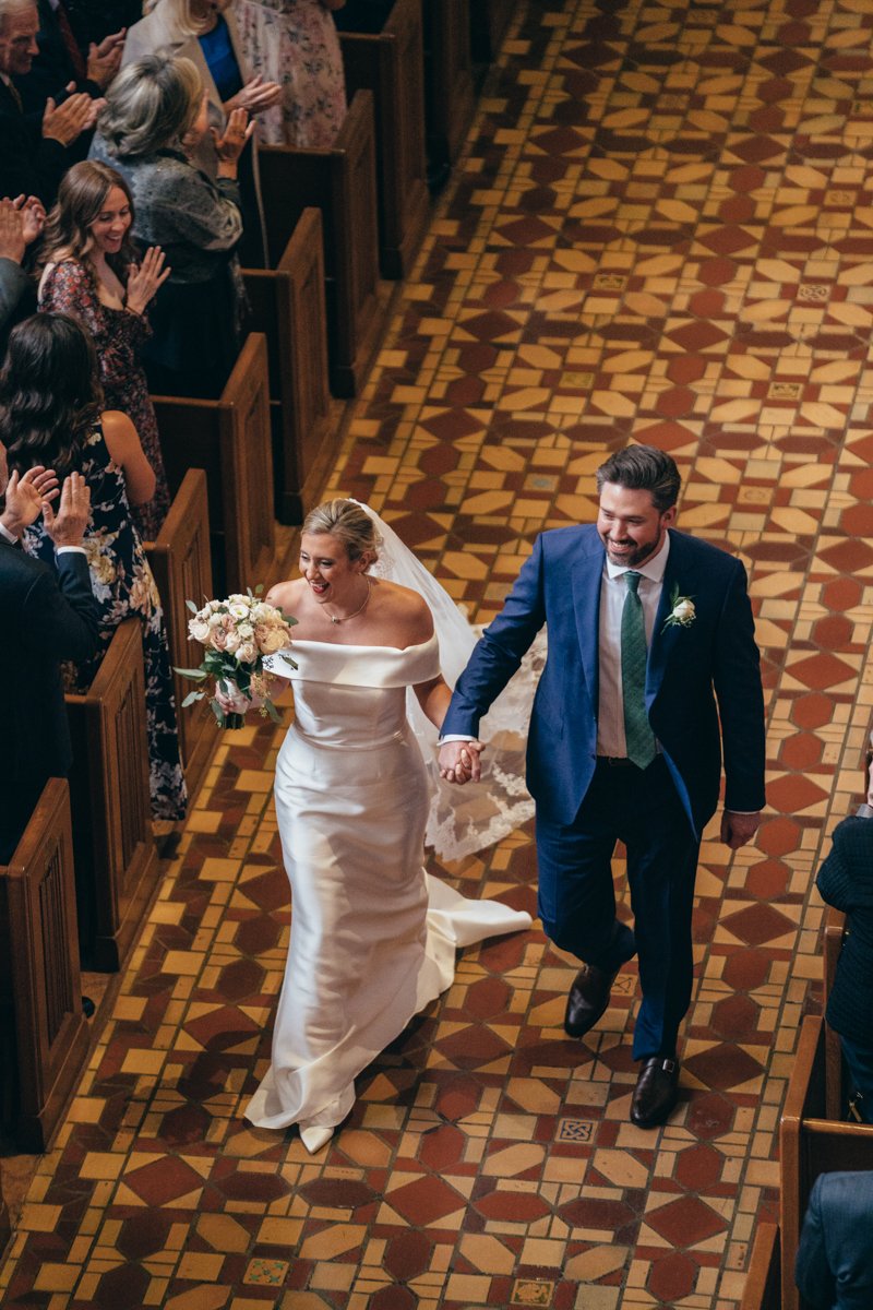 The bride and groom walk down the aisle with big smiles as wedding guests clap.

New York Wedding Photography. Long Island Wedding Photography. Luxury Local Wedding Photographer. Destination Wedding Photographer.