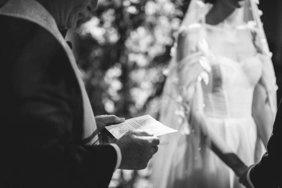 Closeup of a paper in the hands of the wedding officiant. Bride is in the background holding the groom's hands.

Manhattan Wedding Photographer. New York Wedding Photographer. New York Historical Society Wedding. NY Historical Society Weddings.