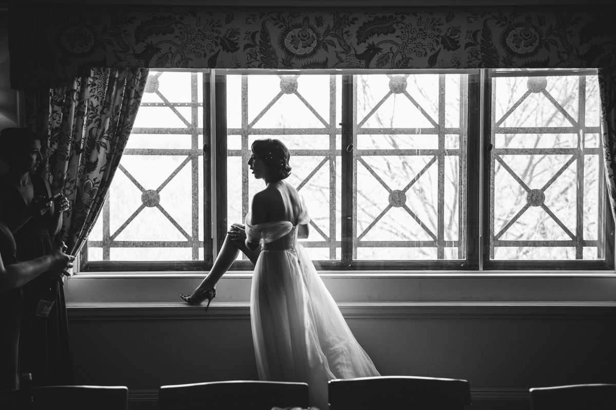 Bride stands in front of a window in her wedding dress. She has her high-heeled foot up on the window sill.

Manhattan Wedding Photographer. New York Wedding Photographer. New York Historical Society Wedding. NY Historical Society Weddings.