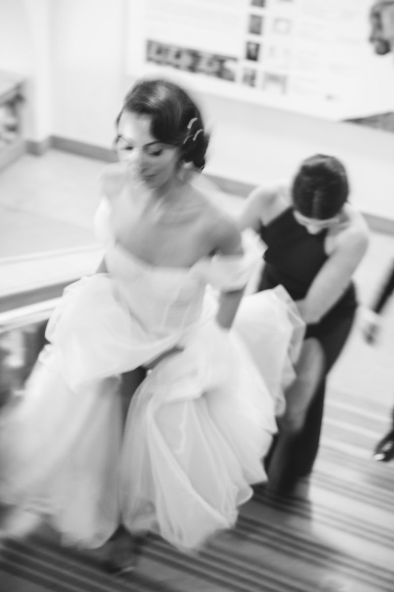 Motion-blurred photograph of bride walking up the stairs with a bridesmaid carrying her train behind her.

Manhattan Wedding Photographer. New York Wedding Photographer. New York Historical Society Wedding. NY Historical Society Weddings.