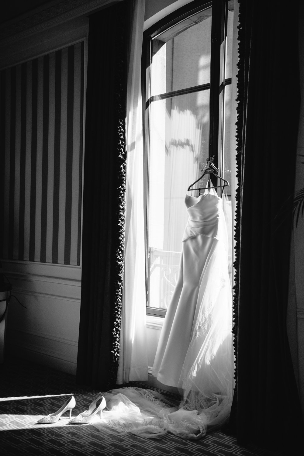 Strapless wedding gown hangs against a tall window as the light shines through into the room.

Manhattan Luxury Wedding. New York Luxury Wedding Photographer. Wedding in Manhattan. NYC Luxury Wedding.