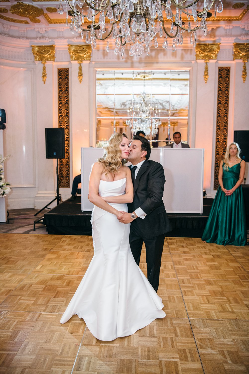 Bride and groom stand in each other's arms and kiss each other on the cheek on the dance floor at the St. Regis.

Manhattan Luxury Wedding. New York Luxury Wedding Photographer. Wedding in Manhattan. NYC Luxury Wedding.
