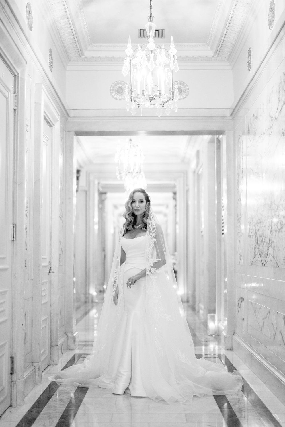 Bride stands in an extravagant hallway at the St Regis Hotel in New York City. She is wearing a wedding dress with a lace-detailed veil.

Manhattan Luxury Wedding. New York Luxury Wedding Photographer. Wedding in Manhattan. NYC Luxury Wedding. 