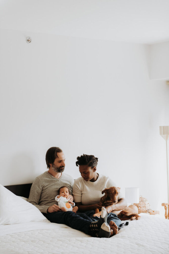 Mother and father sit on their bed with their newborn baby and their dog with them.

Newborn Photography. Brooklyn Newborn Portraits. Lifestyle Newborn Photographer. Brooklyn Family Photography.