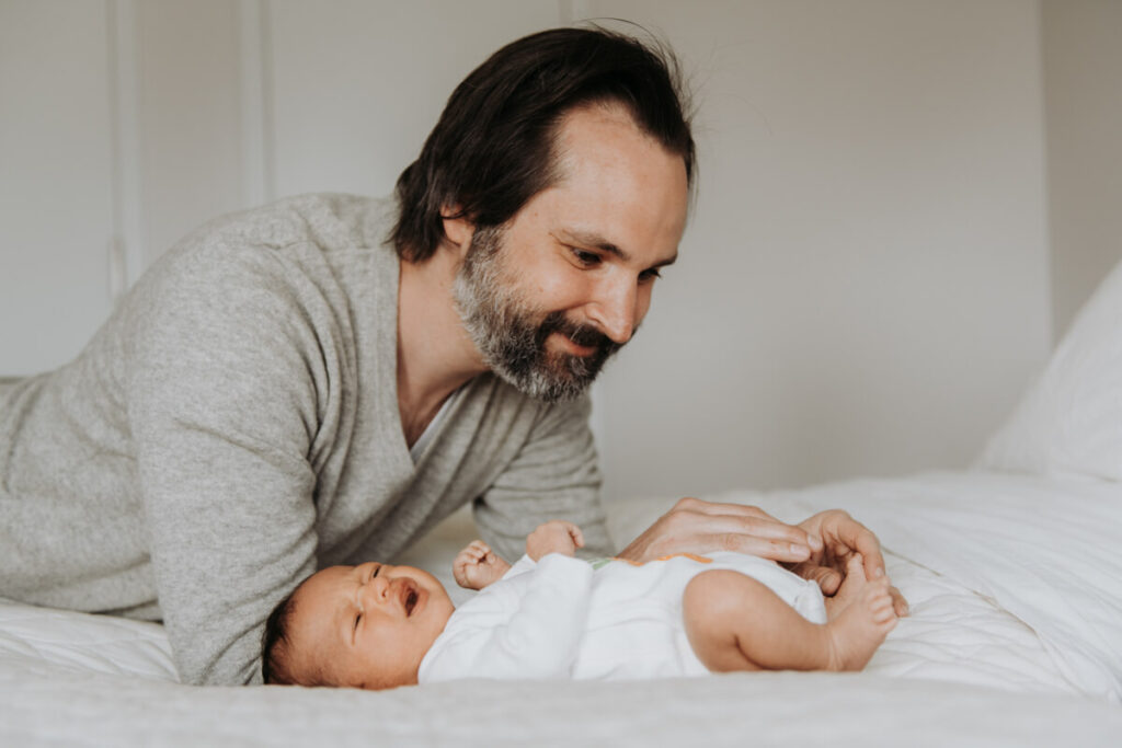Father leans over his newborn baby, who is lying on the bed and crying.

Newborn Photography. Brooklyn Newborn Portraits. Lifestyle Newborn Photographer. Brooklyn Family Photography.