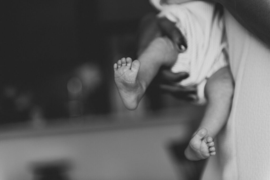 Close-up image of newborn baby's feet as his mother holds him.

Newborn Photography. Brooklyn Newborn Portraits. Lifestyle Newborn Photographer. Brooklyn Family Photography.