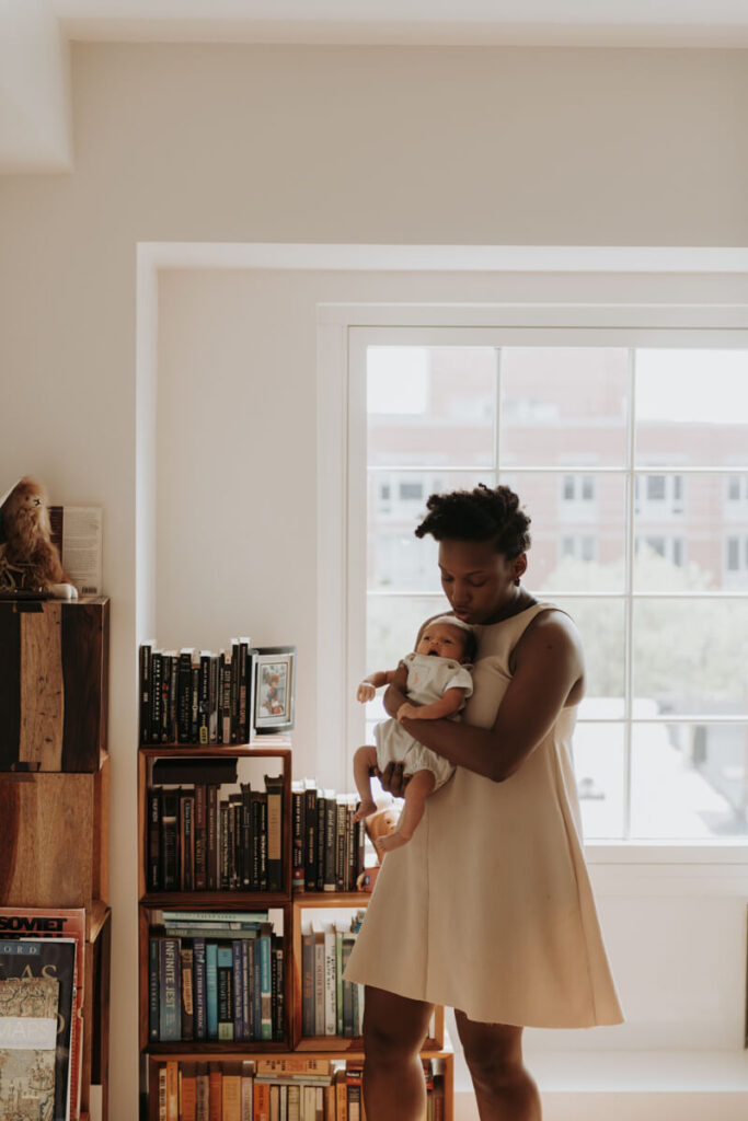 Mother stands in front of window and bookcase with her newborn baby in her arms.

Newborn Photography. Brooklyn Newborn Portraits. Lifestyle Newborn Photographer. Brooklyn Family Photography.
