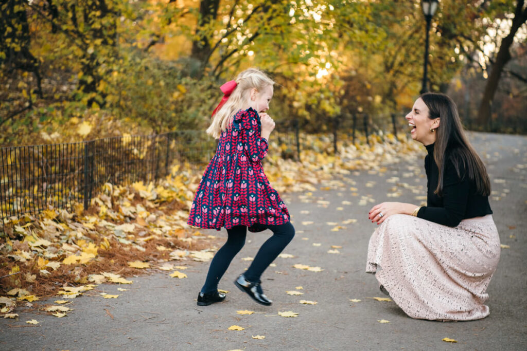 Woman crouches down to the ground as her daughter playfully runs towards her. They are both smiling at each other. Photographed in Central Park.

Manhattan Family Portraits. Central Park Family Photography. NYC Family Photographer.