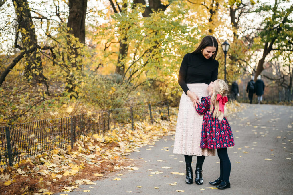 Woman looks down lovingly at her daughter as her daughter leans into her mother and looks up at her with a smile. Photographed in Central Park.

Manhattan Family Portraits. Central Park Family Photography. NYC Family Photographer.