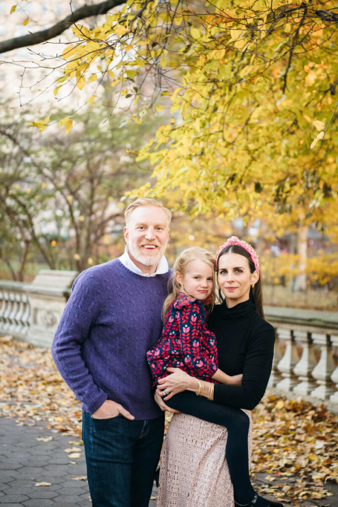Woman has her daughter on her hip and her husband standing  next to her. They are all smiling at the camera. Photographed in Central Park.

Manhattan Family Portraits. Central Park Family Photography. NYC Family Photographer.