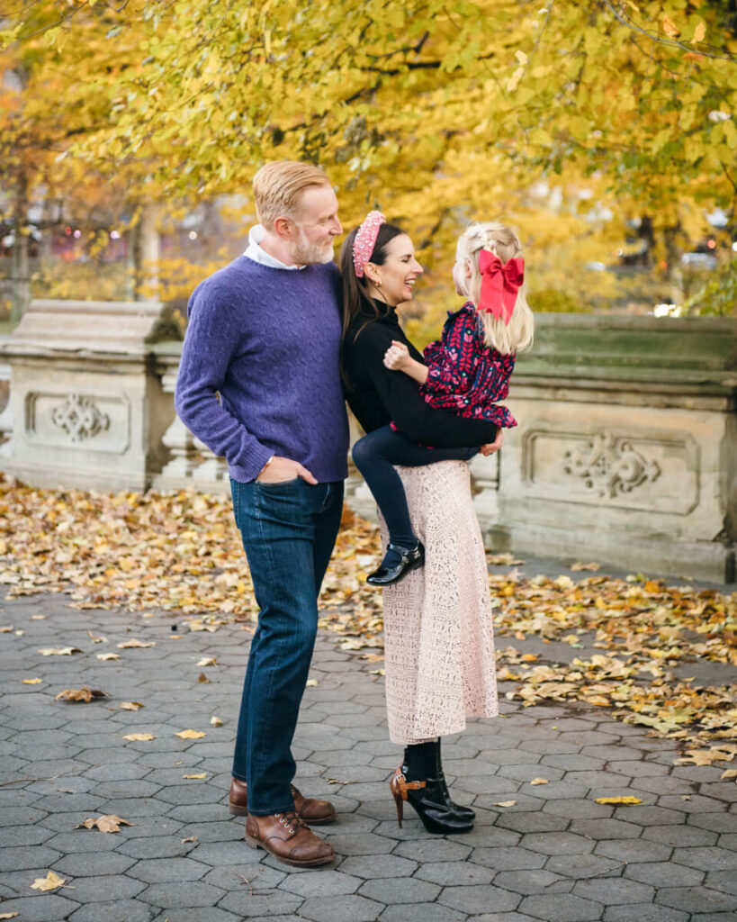 Woman has her daughter on her hip and her husband standing behind her. Husband and wife are both smiling at their daughter. Photographed in Central Park.

Manhattan Family Portraits. Central Park Family Photography. NYC Family Photographer.