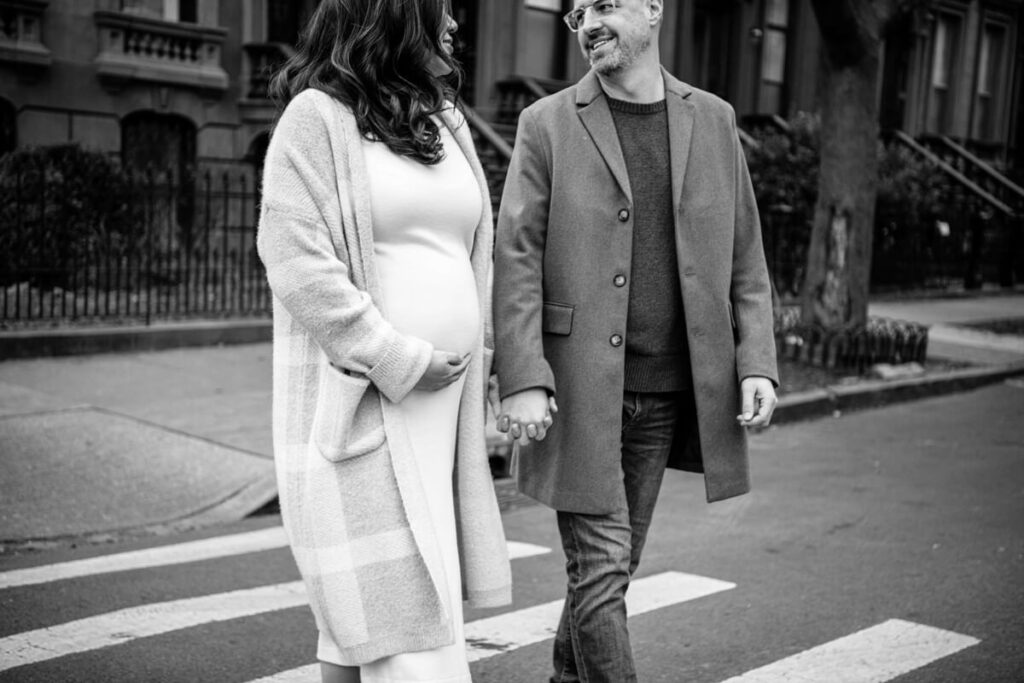 Husband and pregnant wife hold hands and walk across a Brooklyn crosswalk smiling at each other. She has one hand on her baby bump.

Brooklyn Maternity Portraits. Brooklyn Family Photography. NYC Maternity Photographer.
