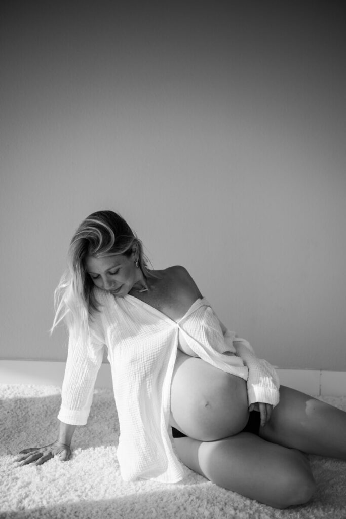 Pregnant woman lounges on a fluffy rug, wearing only a white button down, hand on her belly, looking down and smiling.

Austin Maternity Photography. Austin Maternity Photographer. Austin Maternity Portraits. 