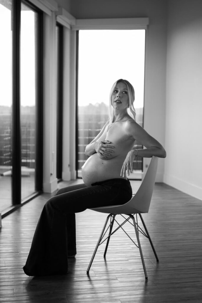 Pregnant woman sitting on a chair in the center of an empty room, wearing only bellbottom pants, hand covering her chest.

Austin Maternity Photography. Austin Maternity Photographer. Austin Maternity Portraits. 