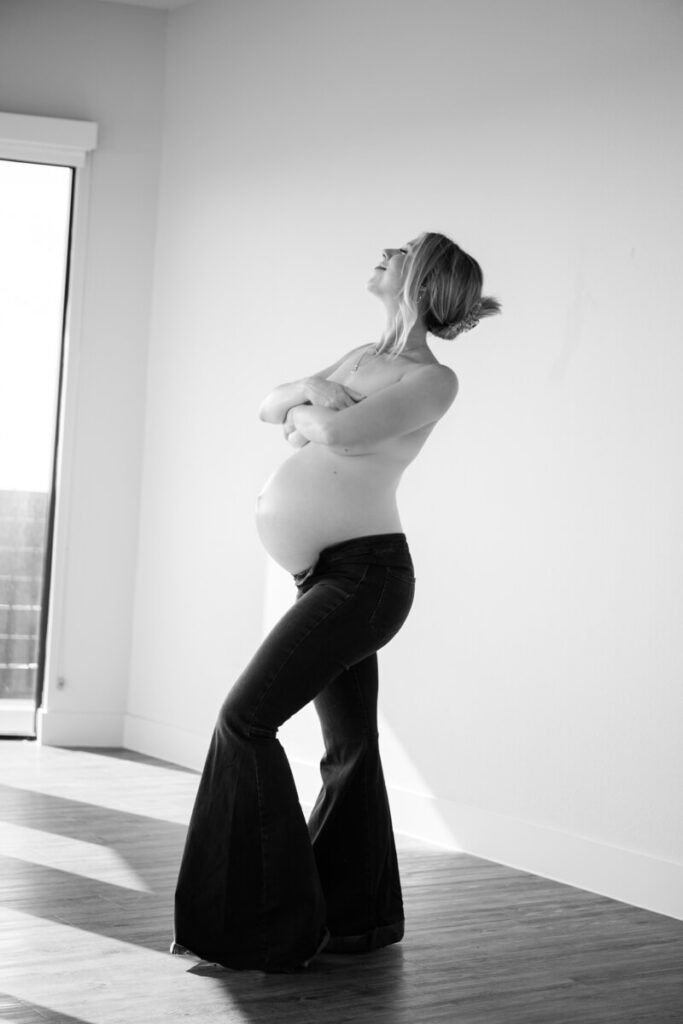 Pregnant woman stands in the center of an empty room, wearing only bellbottom pants, arms crossed over her chest, looking up and smiling.

Austin Maternity Photography. Austin Maternity Photographer. Austin Maternity Portraits. 